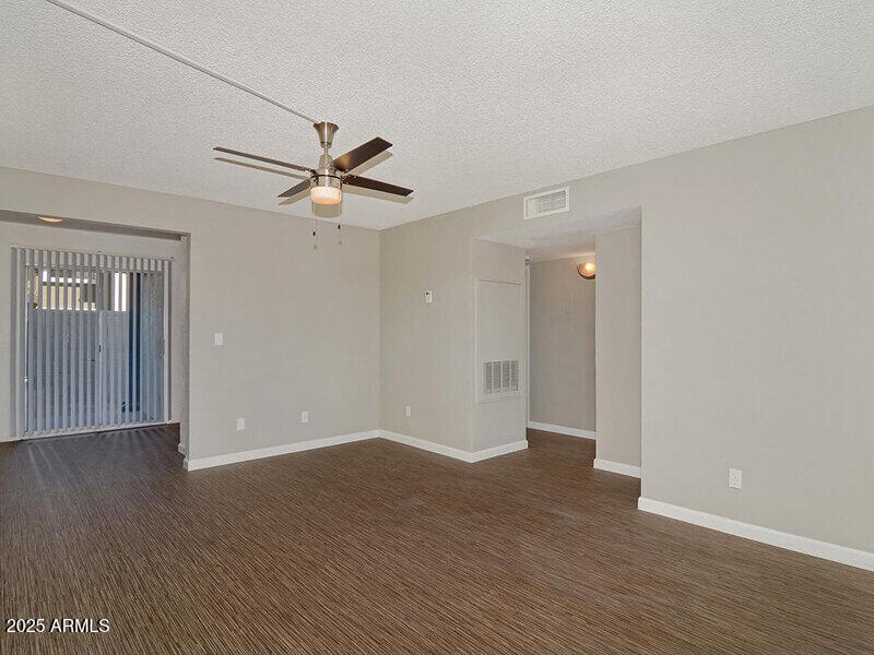 17805 North 40th Street, Unit 2 Phoenix, AZ 85032 - Photo 4 of 13 an empty room with wooden floor and a ceiling fan