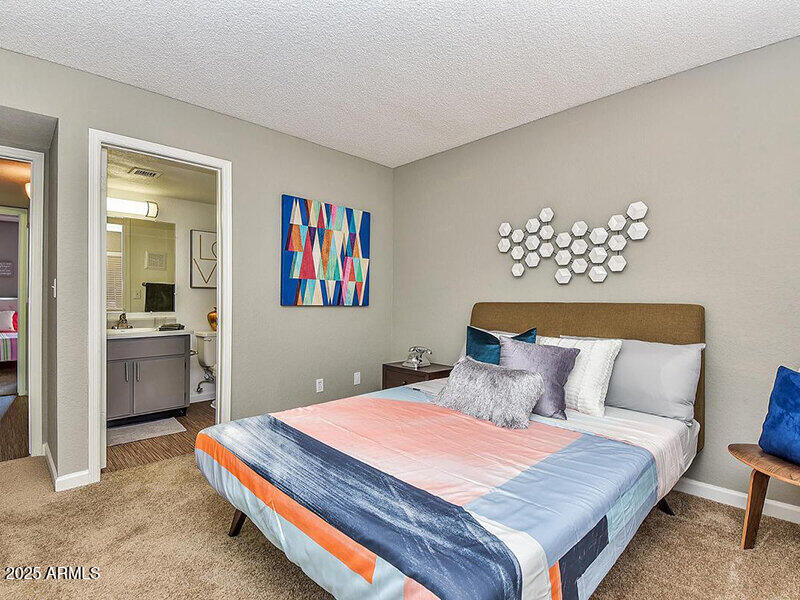 17805 North 40th Street, Unit 2 Phoenix, AZ 85032 - Photo 8 of 13 a bedroom with a bed and a potted plant on dresser