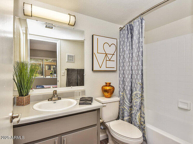 17805 North 40th Street, Unit 2 Phoenix, AZ 85032 - Photo 9 of 13 a bathroom with a sink mirror vanity and toilet