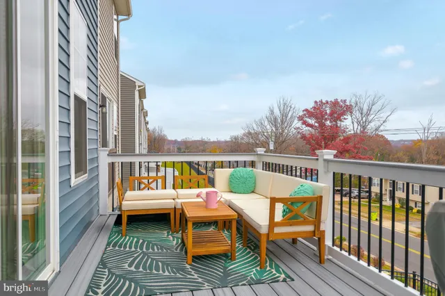a balcony with wooden floor table and chairs