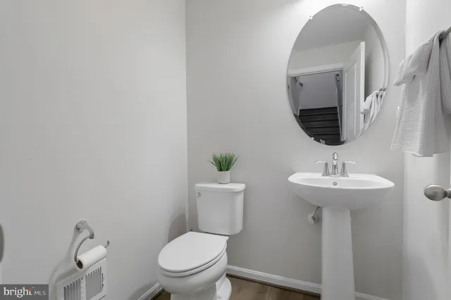 a bathroom with a toilet a sink and mirror
