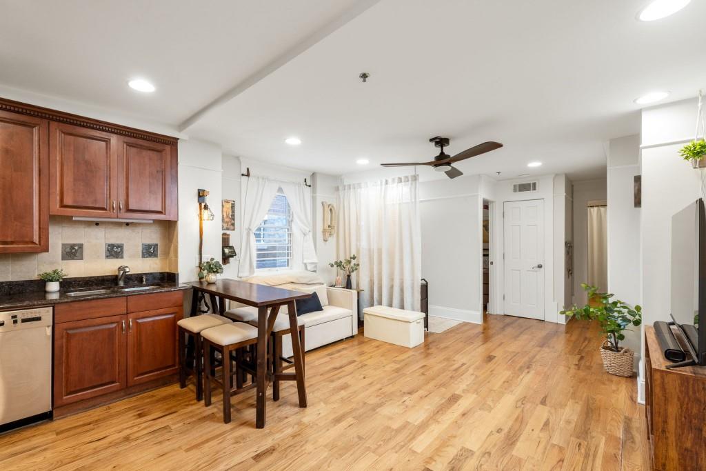 259 14th Street Northeast, Unit B103 Atlanta, GA 30309 - Photo 4 of 33 a kitchen with stainless steel appliances granite countertop a stove a sink dishwasher and a refrigerator with wooden floor