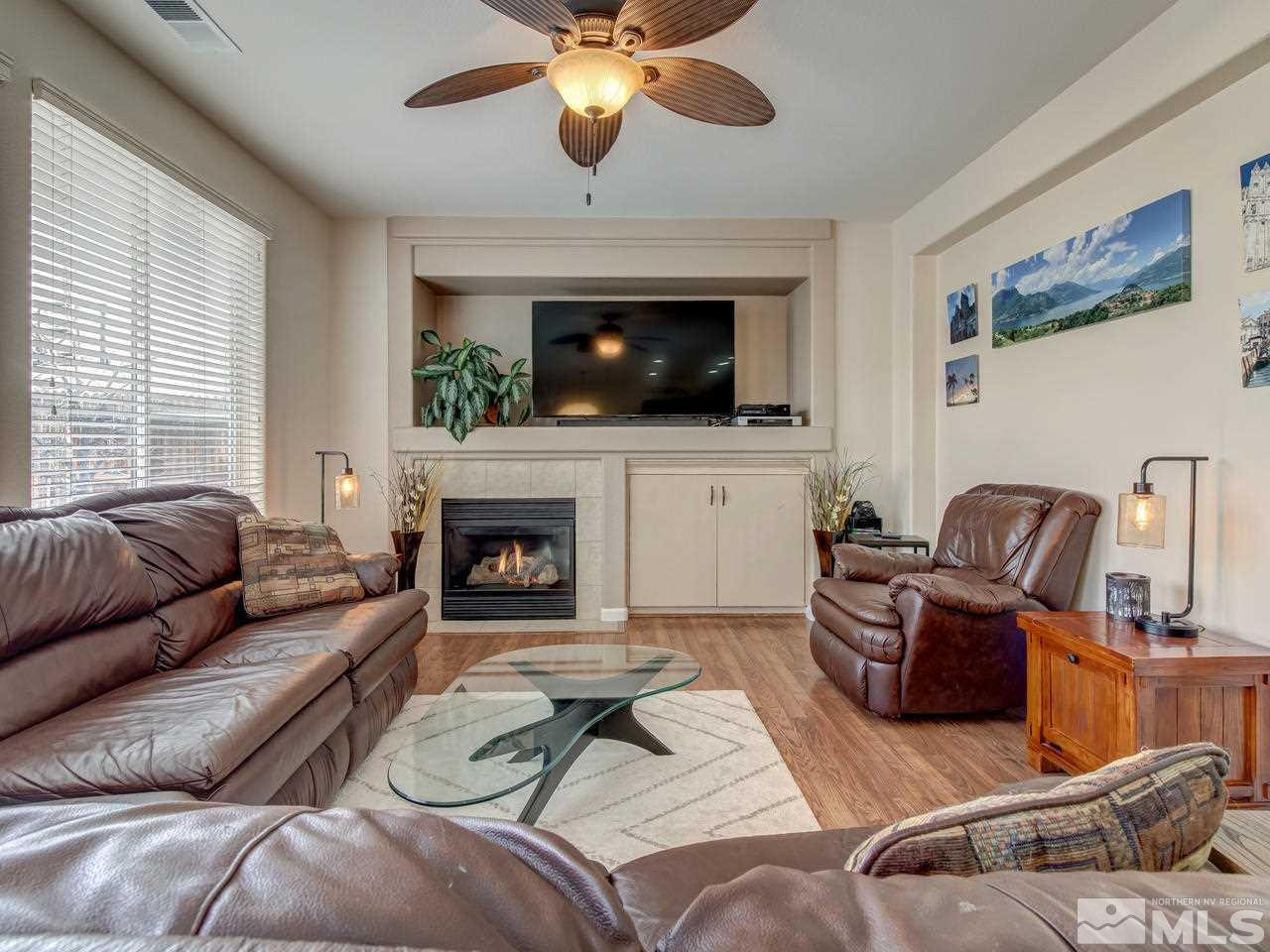 1723 Cavern Drive Reno, NV 89521 - Photo 10 of 25 a living room with furniture a fireplace and a flat screen tv