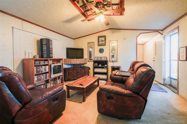 a living room with furniture a flat screen tv and a large window