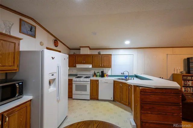 a kitchen with stainless steel appliances granite countertop a refrigerator a stove and a sink