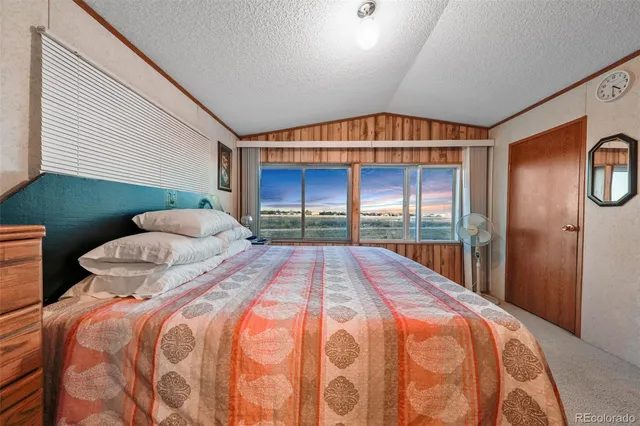 a bedroom with a bed and a large window
