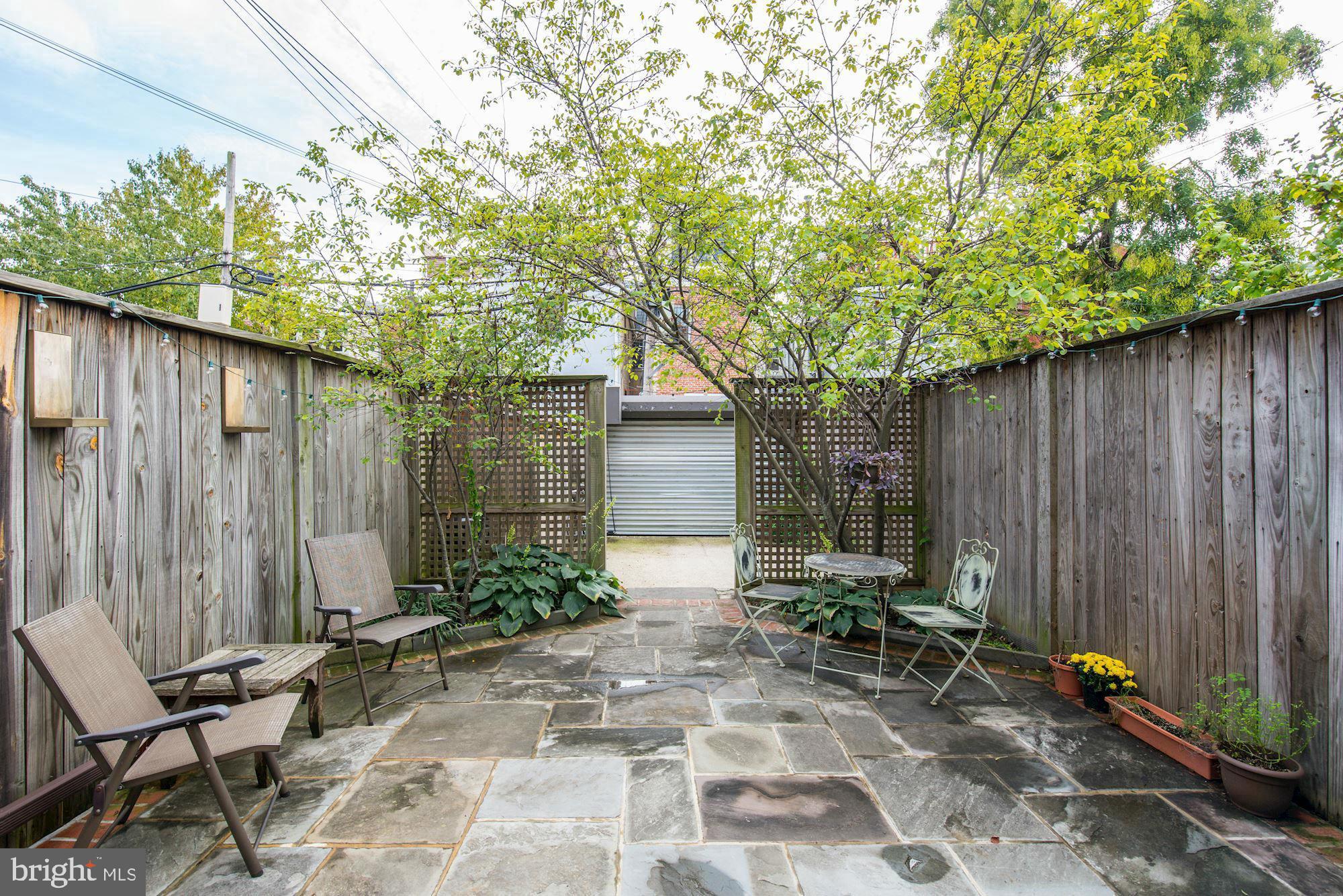 1414 Swann Street Northwest Washington, DC 20009 - Photo 17 of 38 a backyard of a house with chairs and tree
