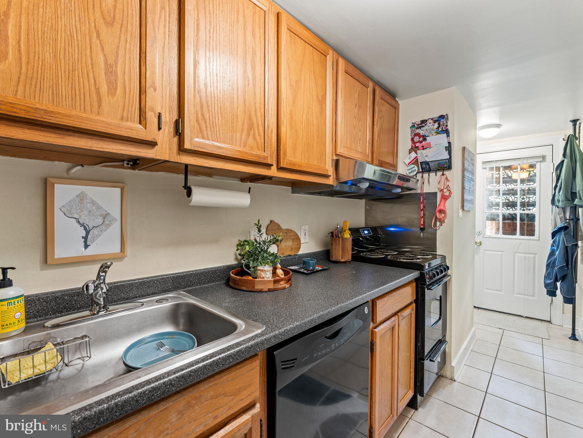 1414 Swann Street Northwest Washington, DC 20009 - Photo 30 of 38 a kitchen with stainless steel appliances granite countertop a sink stove and cabinets