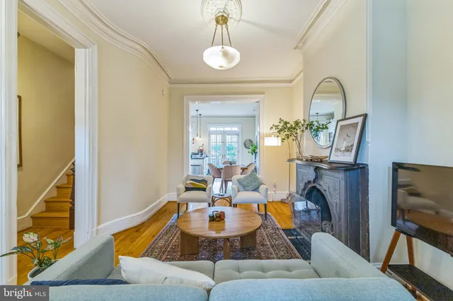 a living room with furniture a flat screen tv and a window