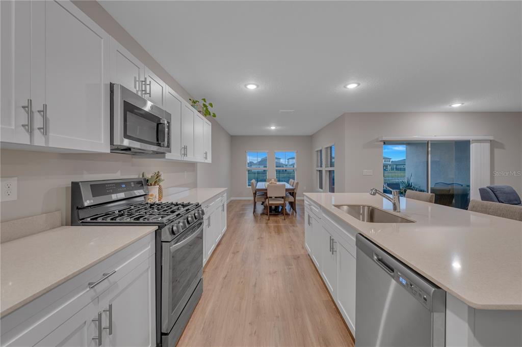 12710 Hysmith Loop Parrish, FL 34219 - Photo 15 of 45 a large kitchen with stainless steel appliances granite countertop lots of counter space a sink and a stove