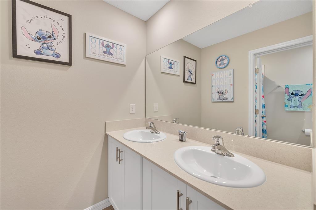 12710 Hysmith Loop Parrish, FL 34219 - Photo 31 of 45 a bathroom with a double vanity sink and a mirror