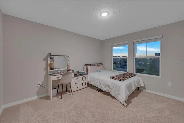 a bedroom with a bed and a lamp on dresser