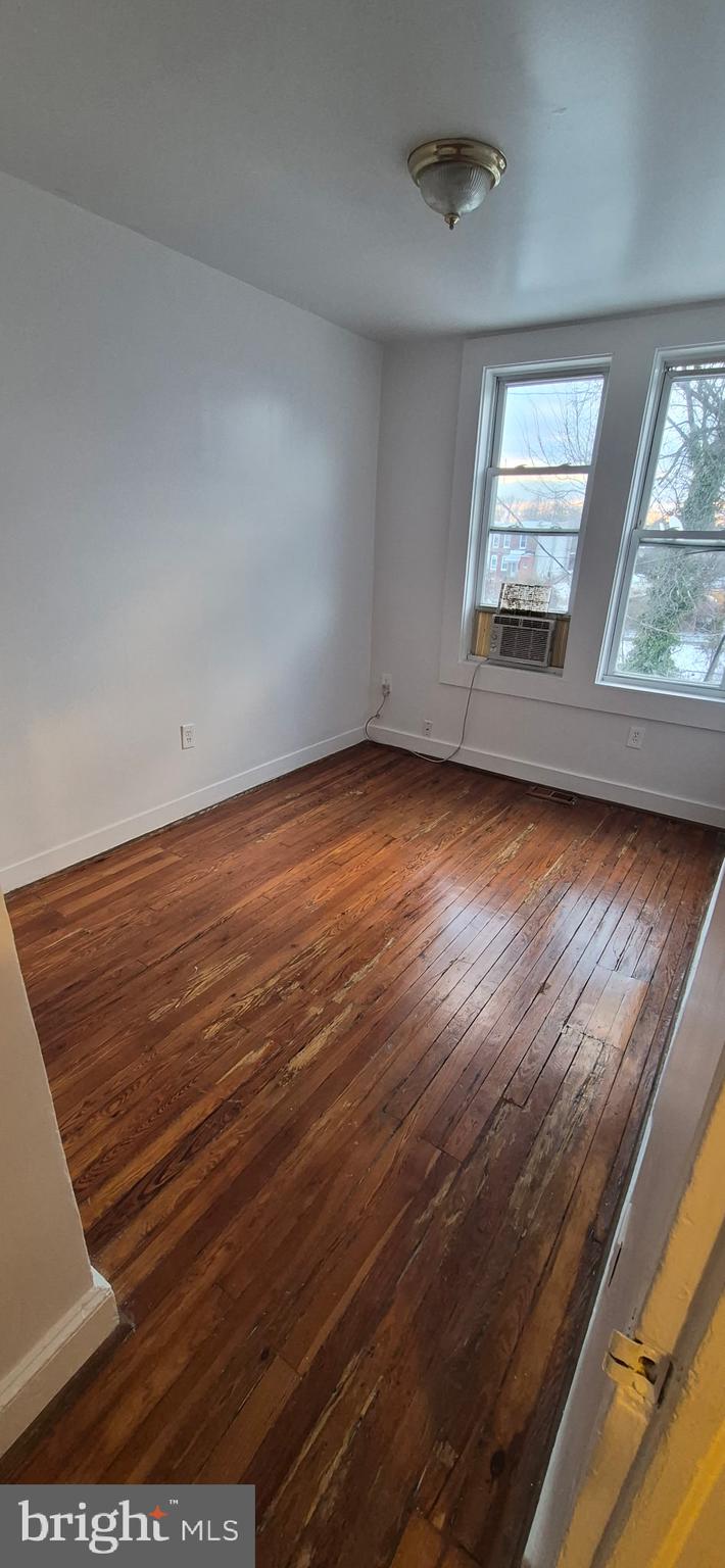 4620 Pall Mall Road Baltimore, MD 21215 - Photo 2 of 10 an empty room with wooden floor and windows