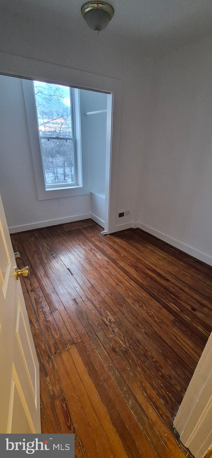 4620 Pall Mall Road Baltimore, MD 21215 - Photo 3 of 10 a view of an empty room with wooden floor and a window