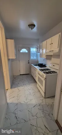 a kitchen with granite countertop a stove a sink and a refrigerator