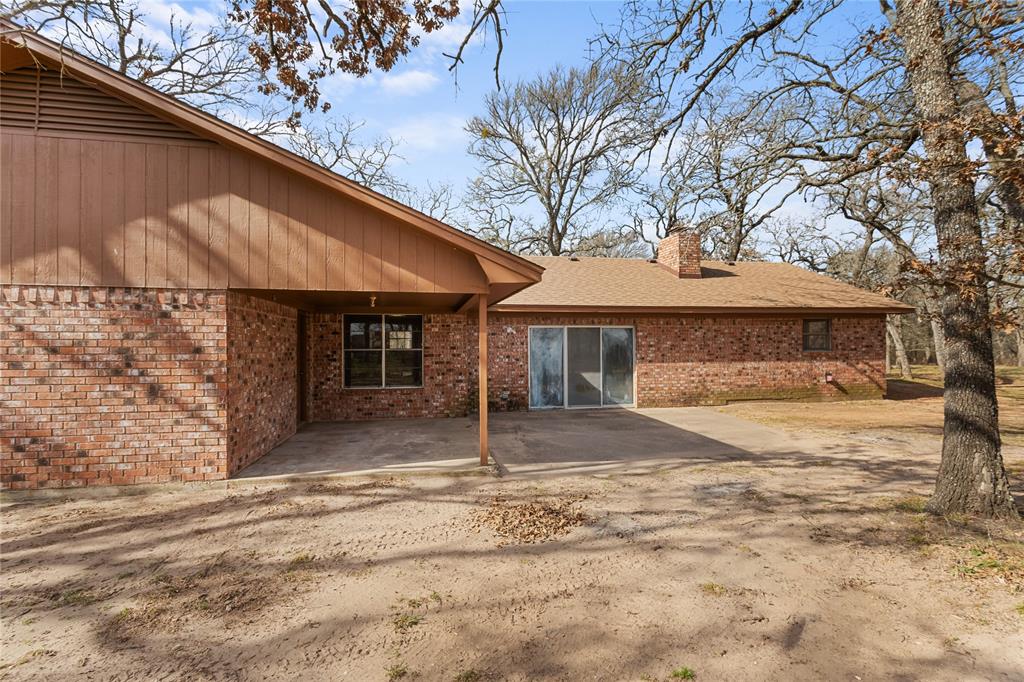 1447 Red Gate Road Mart, TX 76664 - Photo 20 of 38 a front view of a house with a garden and tree