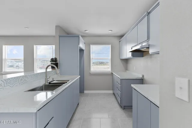 a kitchen with a sink stove and cabinets
