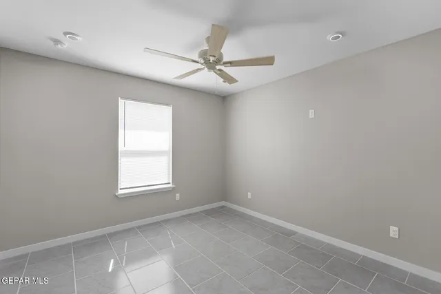 an empty room with windows and fan