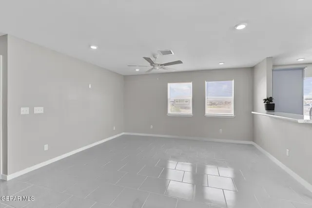 an empty room with windows and cabinet