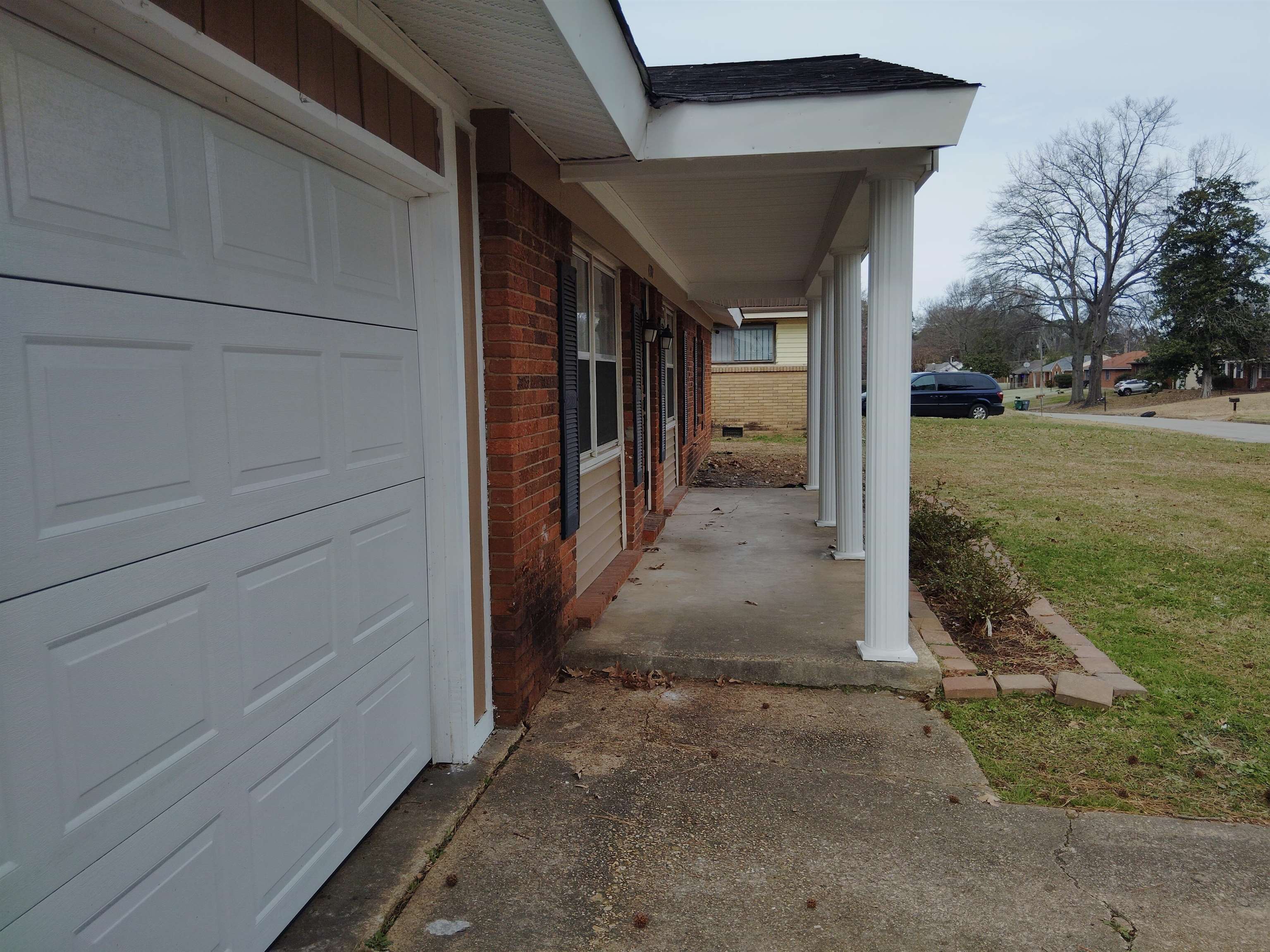 4307 Sidney Road Memphis, TN 38116 - Photo 2 of 18 View of home's exterior featuring brick siding, covered porch, a lawn, and a shingled roof