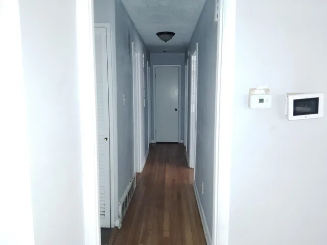 a view of a hallway with wooden floor