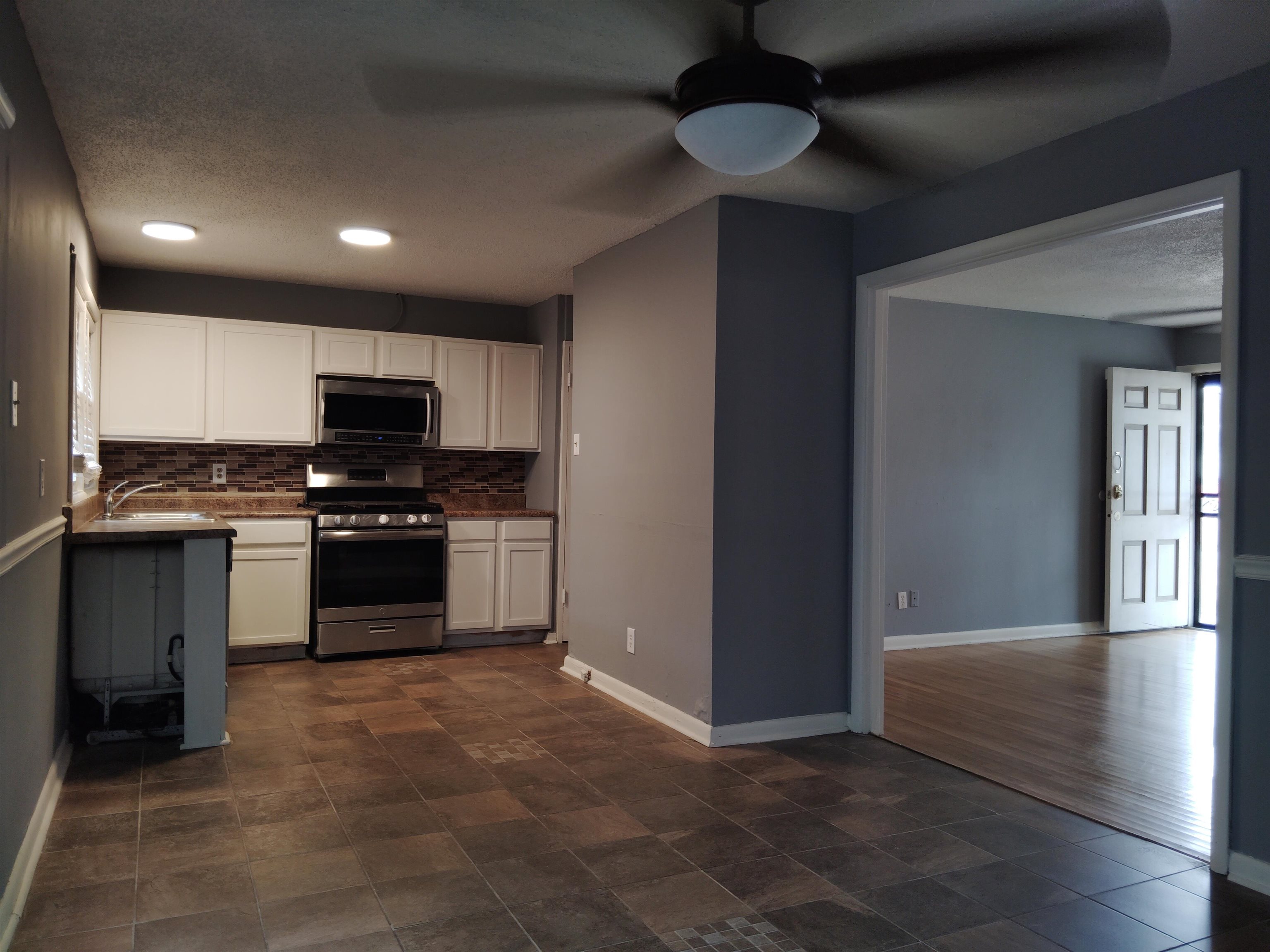 4307 Sidney Road Memphis, TN 38116 - Photo 6 of 18 Kitchen featuring white cabinets, appliances with stainless steel finishes, a textured ceiling, ceiling fan, and decorative backsplash