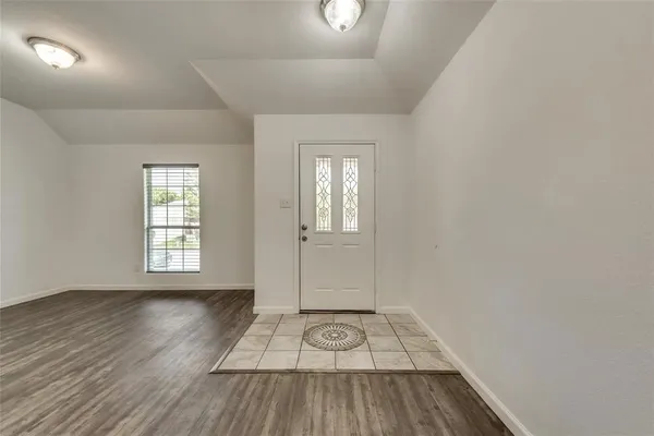 a view of a room with wooden floor and white walls