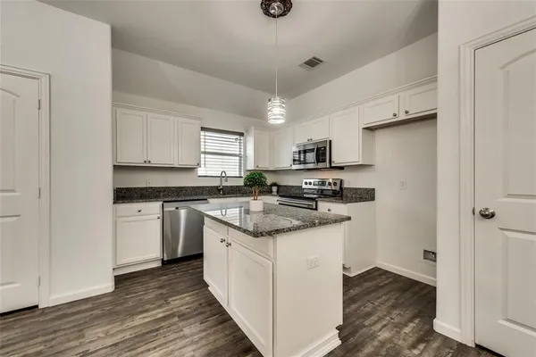 a kitchen with stainless steel appliances a sink a stove a refrigerator and cabinets