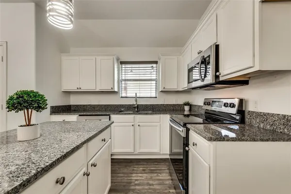a kitchen with stainless steel appliances granite countertop a sink stove and cabinets