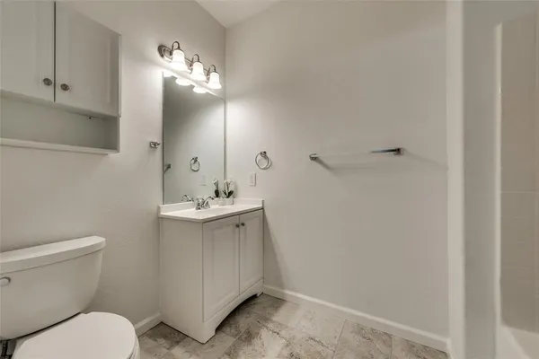 a bathroom with a toilet a sink and mirror