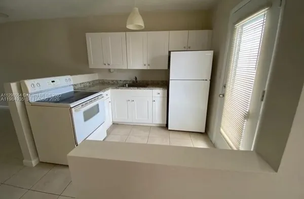 a kitchen with a refrigerator sink stove and cabinets