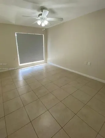 an empty room with a ceiling fan and carpet