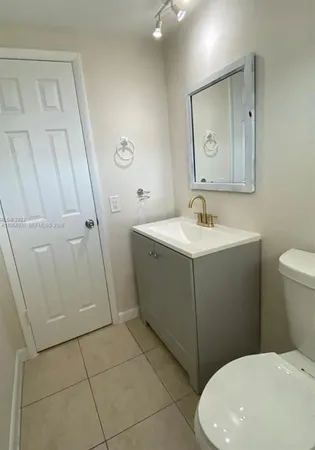 a bathroom with a sink a toilet and mirror