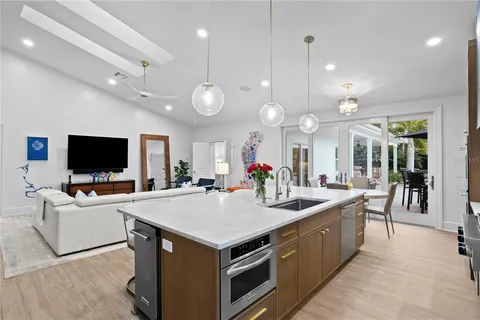 a large kitchen with kitchen island a sink table and chairs