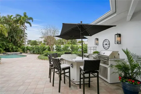 a patio with a table and chairs under an umbrella