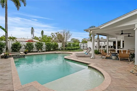 a view of a swimming pool with outdoor seating and plants