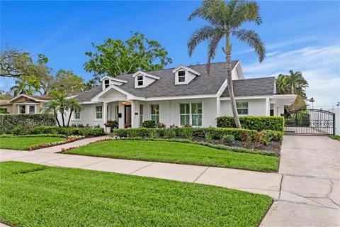 a front view of a house with a yard and potted plants
