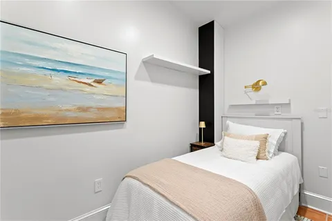 a bedroom with a bed and a painting on the wall