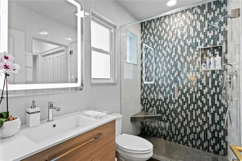 a bathroom with a sink a toilet and shower