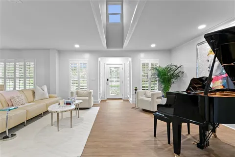a living room with furniture a flat screen tv and a large window