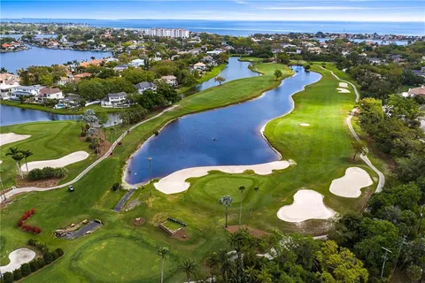 an aerial view of a pool yard tennis courts and ocean view