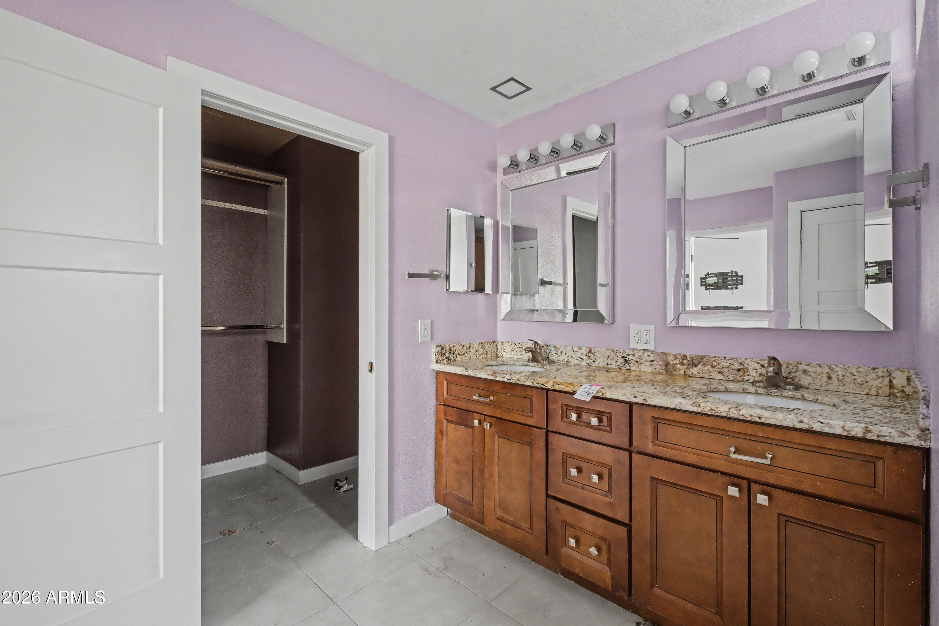 3925 West Charter Oak Road Phoenix, AZ 85029 - Photo 27 of 39 a bathroom with a granite countertop sink a large mirror and a refrigerator