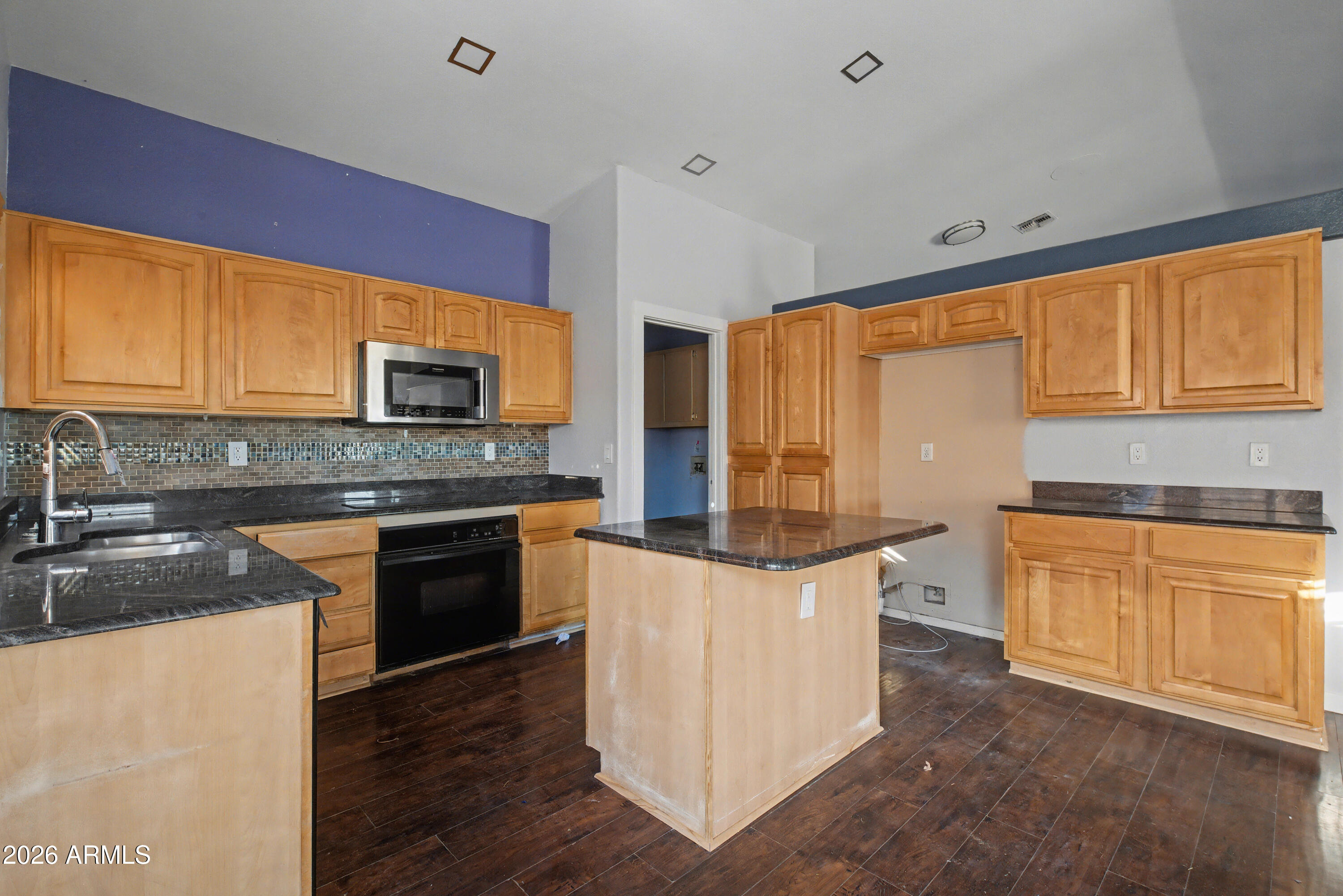 3925 West Charter Oak Road Phoenix, AZ 85029 - Photo 10 of 39 a kitchen with stainless steel appliances granite countertop wooden cabinets a stove top oven a sink and dishwasher with wooden floor