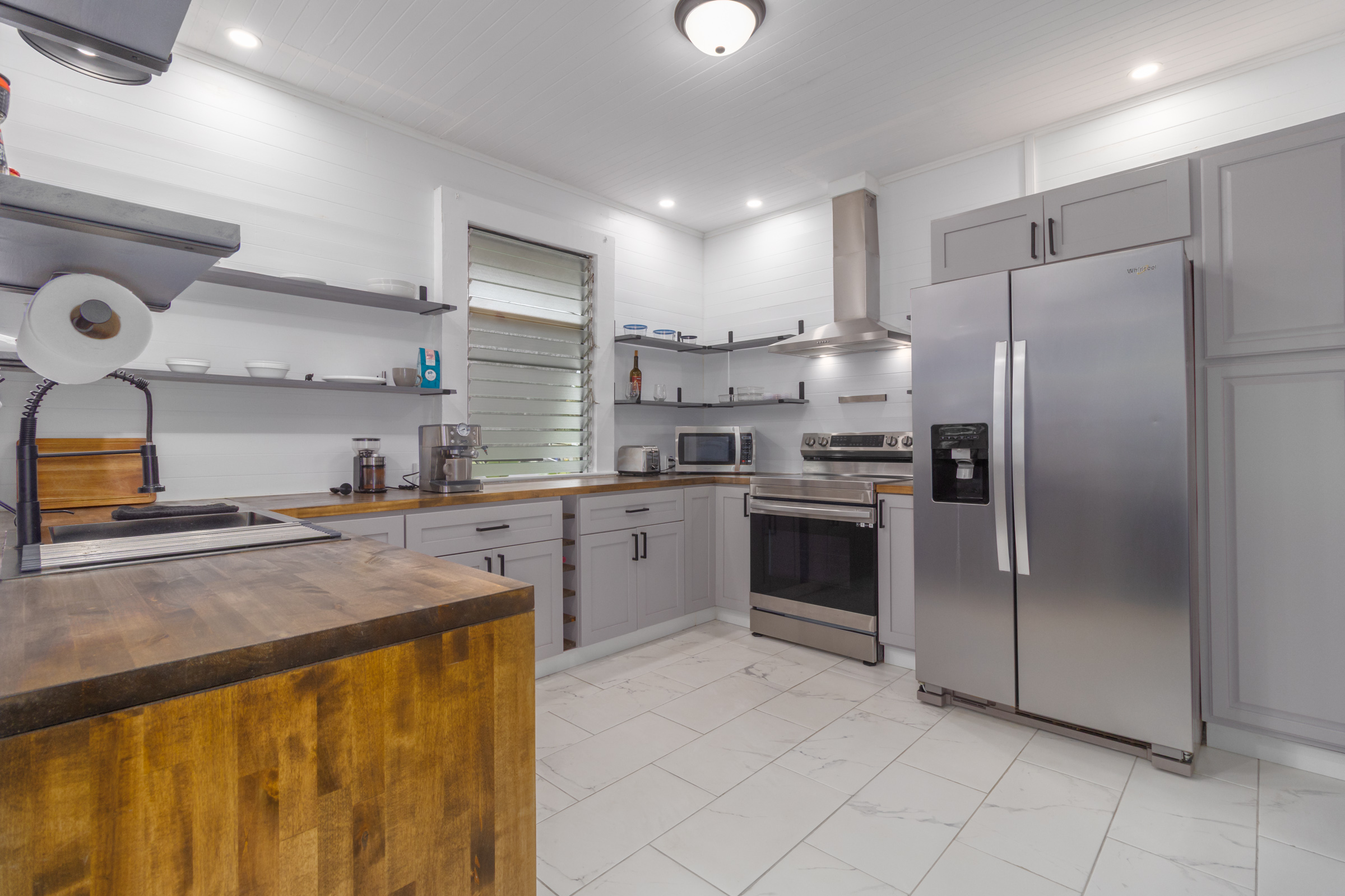 110 Malia Street Hilo, HI 96720 - Photo 9 of 27 a kitchen with a refrigerator sink and cabinets