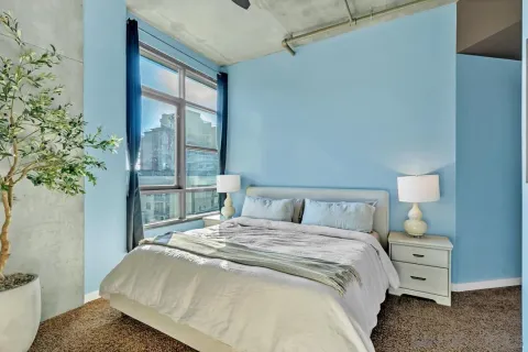 a bedroom with a bed and a large window