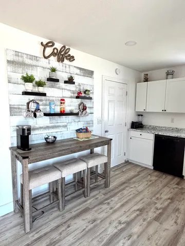 a kitchen with granite countertop a wooden floor and cabinets