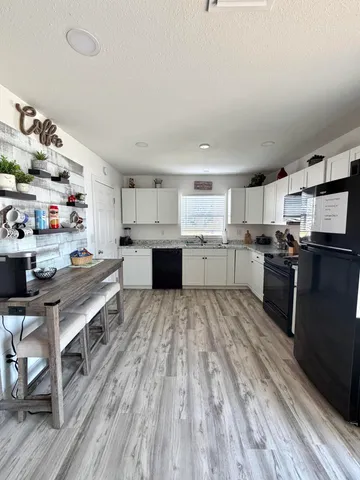 a kitchen with stainless steel appliances a stove top oven a sink dishwasher and a refrigerator