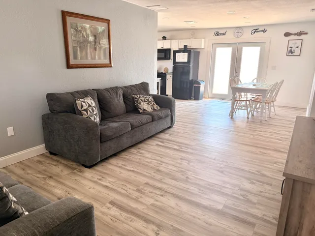 a living room with furniture wooden floor and a table