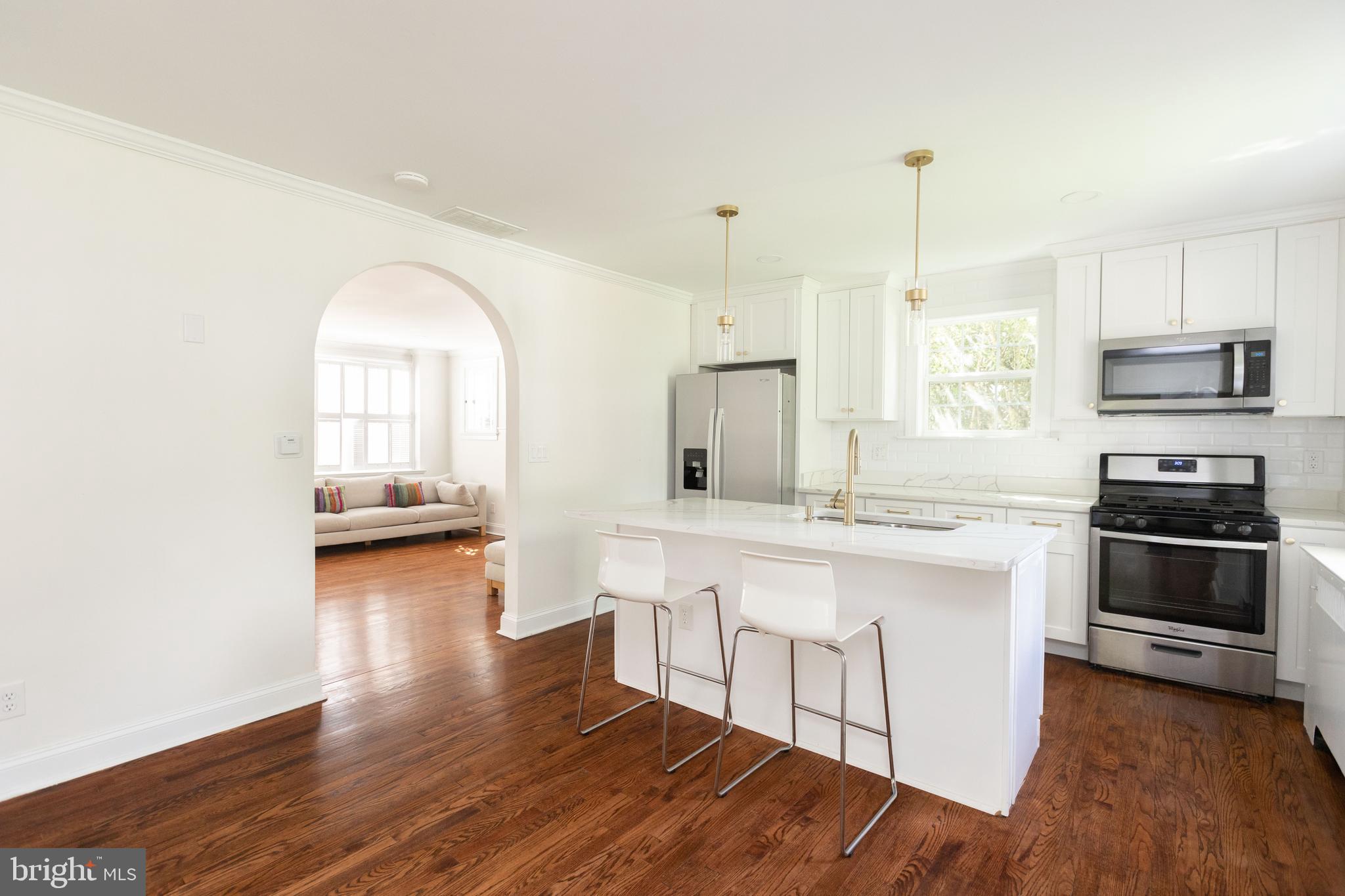 710 Regester Avenue Baltimore, MD 21212 - Photo 13 of 48 a kitchen with stainless steel appliances a stove a sink a center island and wooden floor