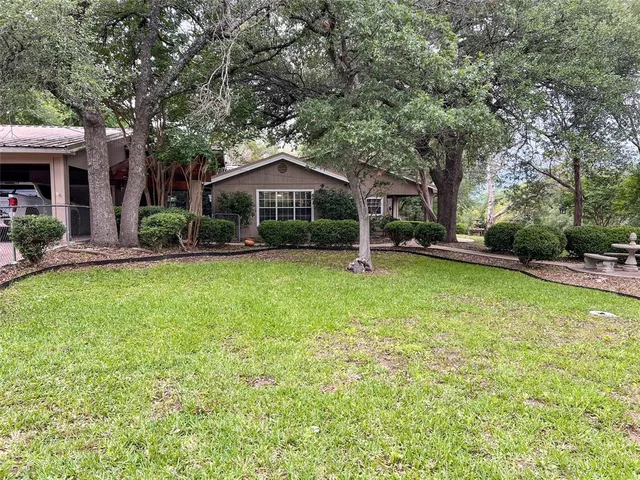 a front view of a house with a yard and trees